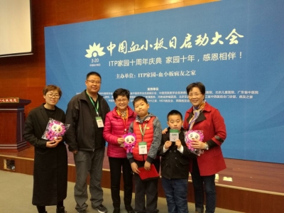 家园志愿者为义诊专家献上中国血小板日吉祥物